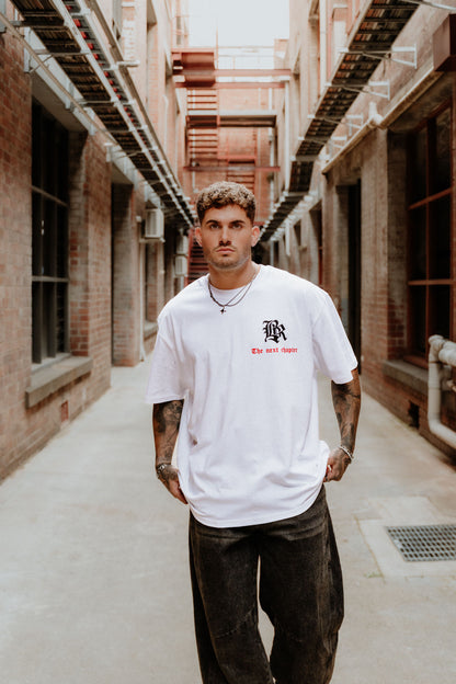 male model wearing white, black and red streetwear tee, urban setting