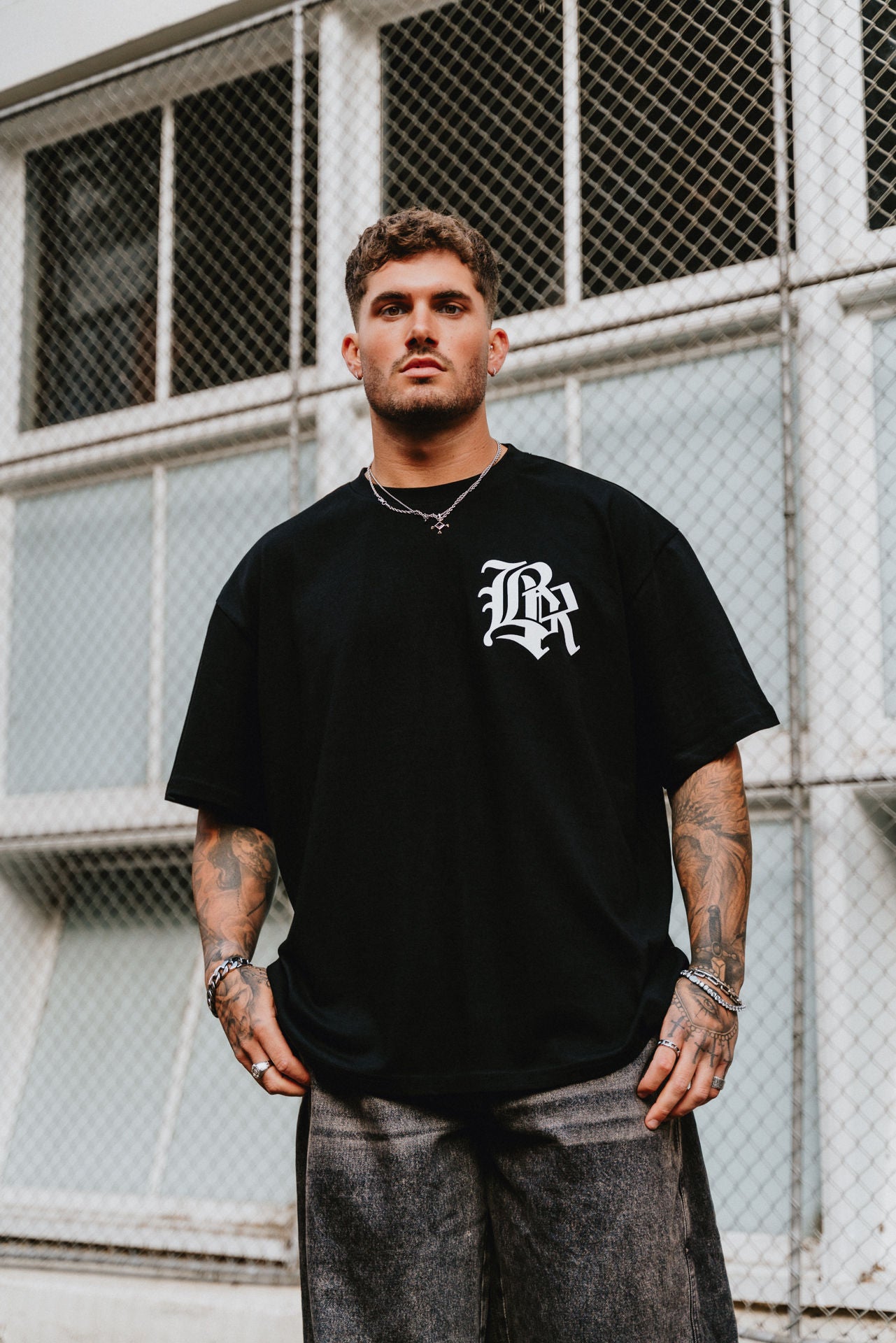 male model wearing black t-shirt in an urban setting