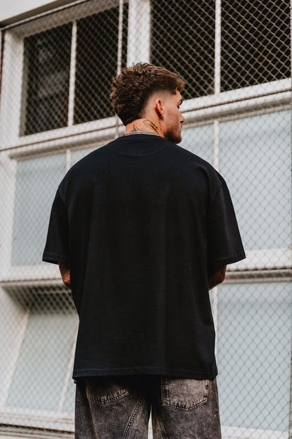 male model facing away wearing black t-shirt in an urban setting