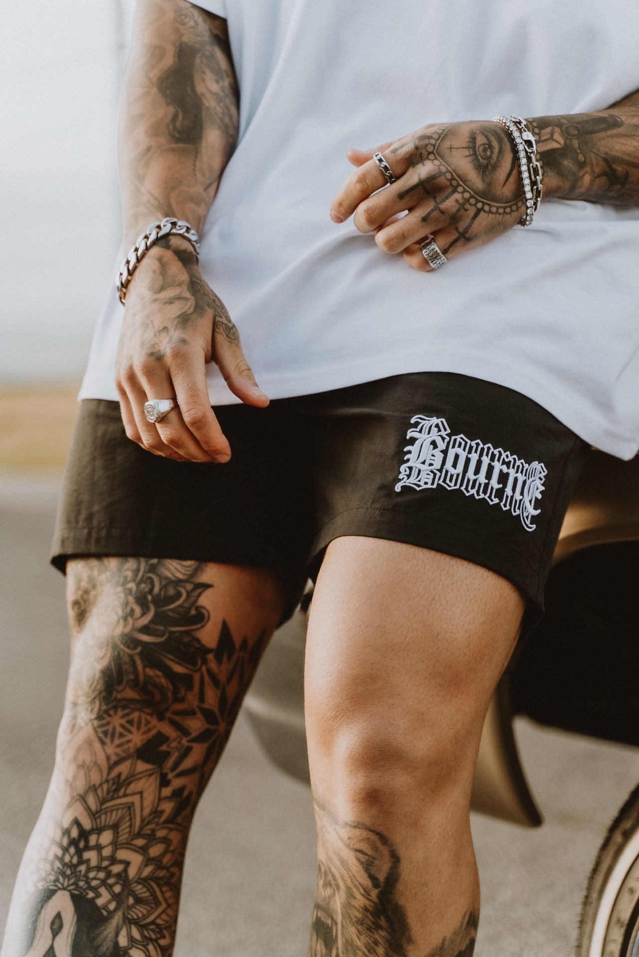 a pair or swim shorts, male model with tattoos and jewelry