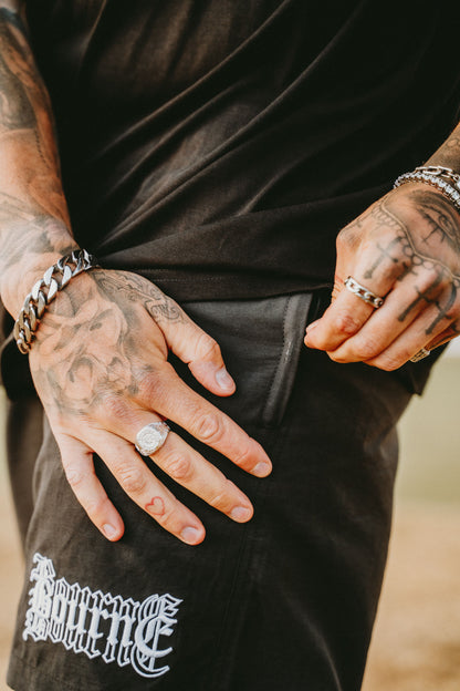 a pair or swim shorts, male model with tattoos and jewellery