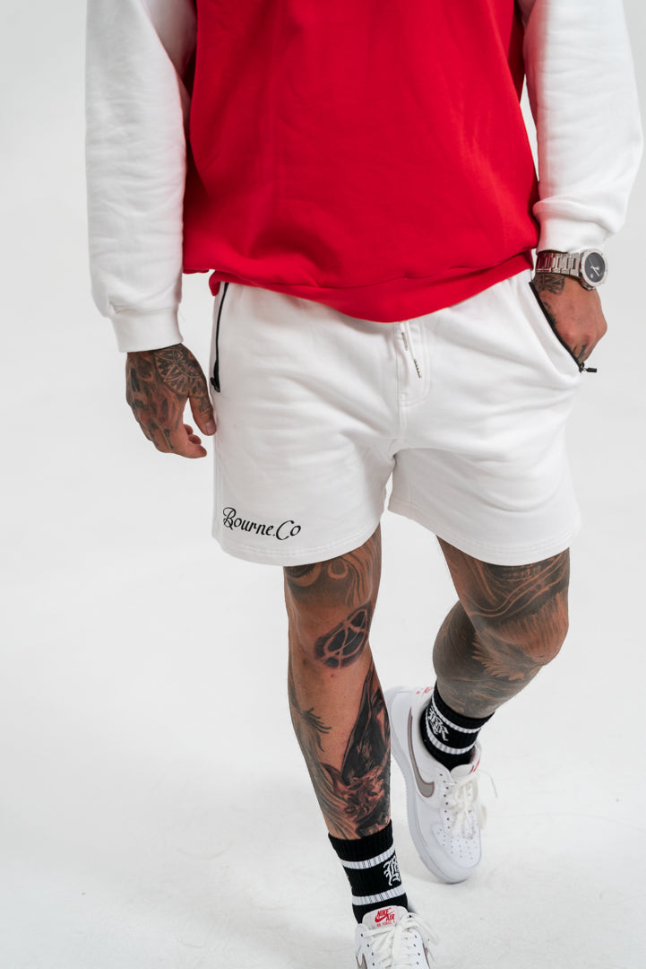 male model wearing a red and white crewneck hoodie and white bottoms, white background